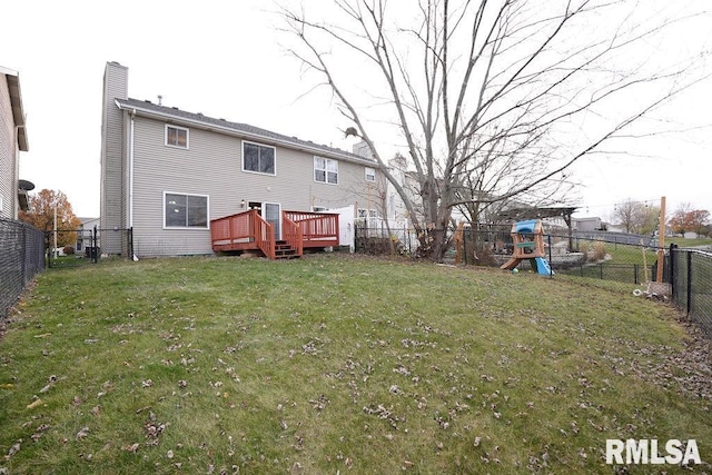 rear view of house with a lawn, a playground, and a wooden deck