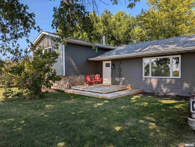 entrance to property with a wooden deck and a yard