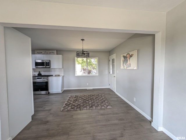 unfurnished dining area with dark hardwood / wood-style floors and a notable chandelier