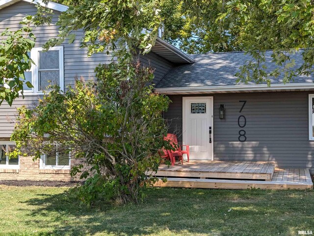 back of house featuring a garage, a wooden deck, and a yard