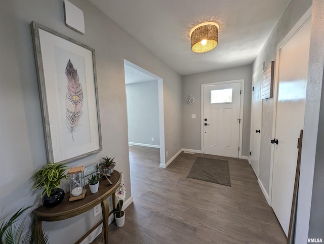 foyer with dark wood finished floors and baseboards