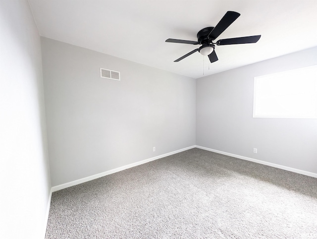 spare room with a ceiling fan, carpet flooring, visible vents, and baseboards