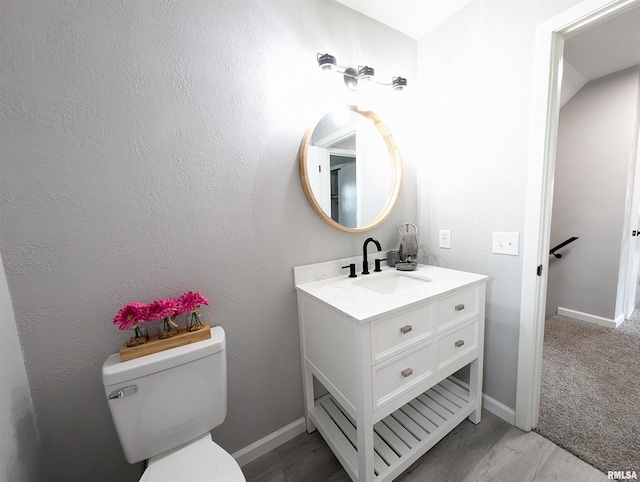 half bath with vanity, toilet, and baseboards