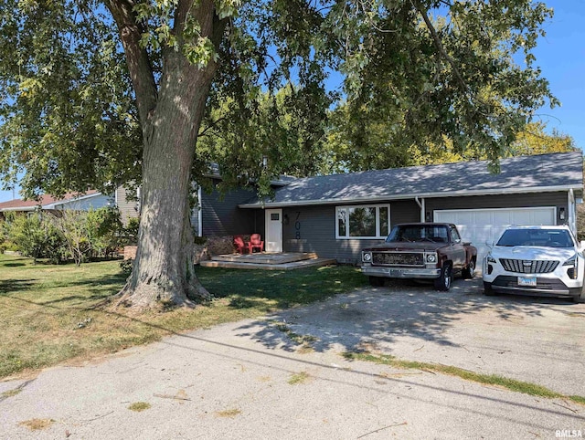 single story home with an attached garage, a front lawn, and aphalt driveway