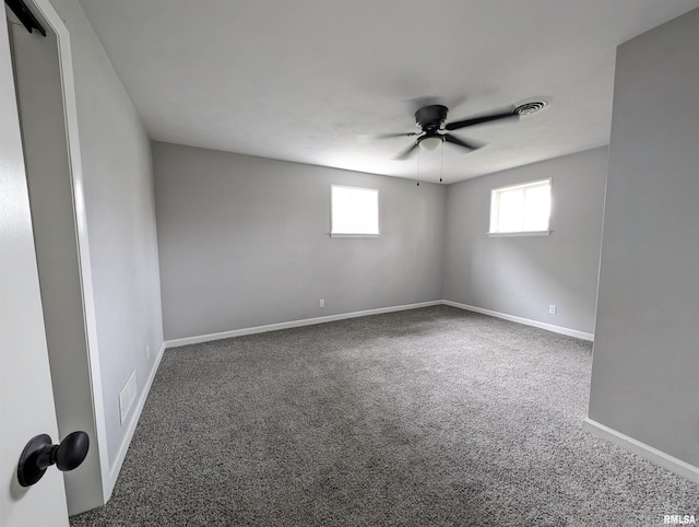 empty room featuring carpet floors, visible vents, ceiling fan, and baseboards