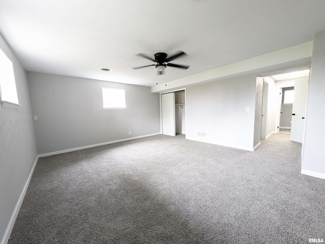 interior space with a ceiling fan, carpet, visible vents, and baseboards