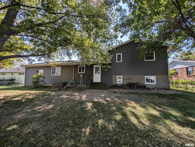 tri-level home featuring entry steps, central air condition unit, and a front yard