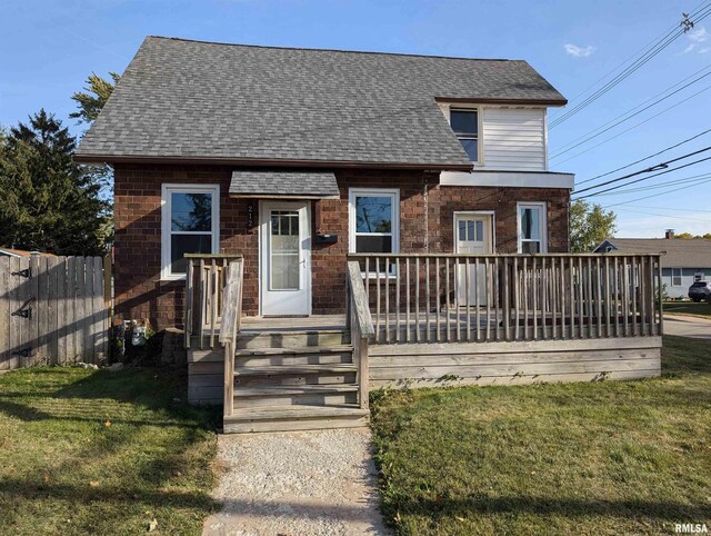 back of property with a wooden deck and a yard