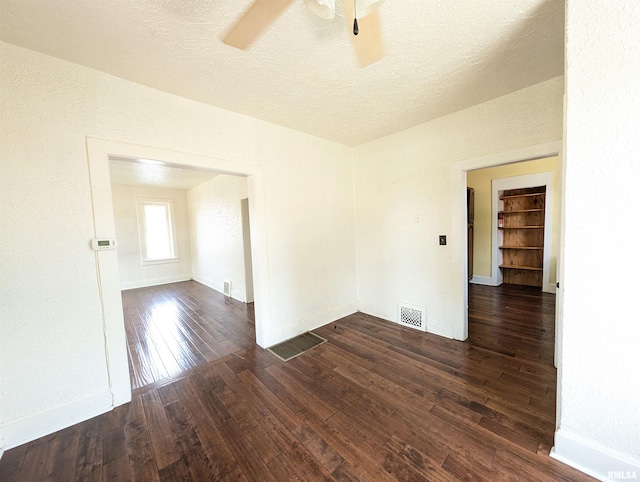 empty room with visible vents, ceiling fan, a textured ceiling, baseboards, and hardwood / wood-style flooring