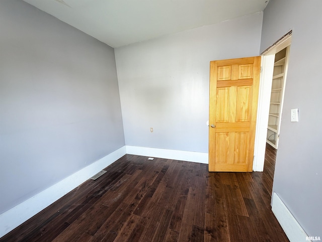 spare room with dark wood-type flooring