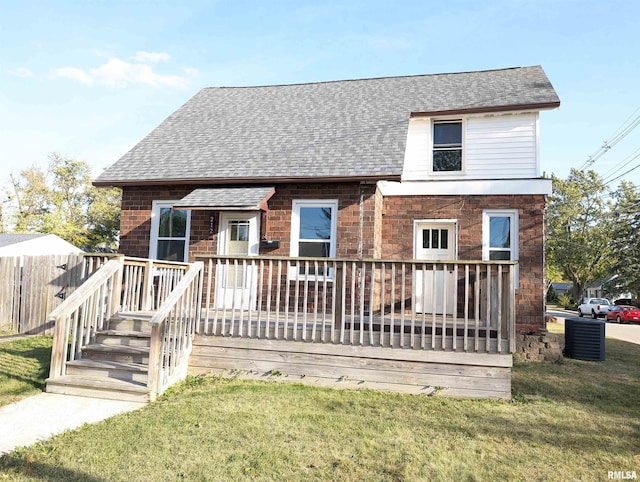 view of front facade with a front lawn, a shingled roof, and brick siding