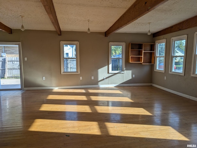 interior space featuring beam ceiling, a textured ceiling, and hardwood / wood-style flooring