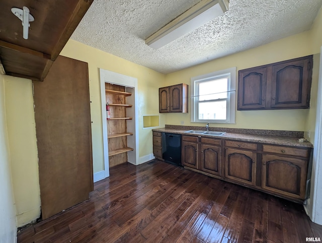 kitchen with a textured ceiling, dark brown cabinetry, dark wood-type flooring, sink, and black dishwasher