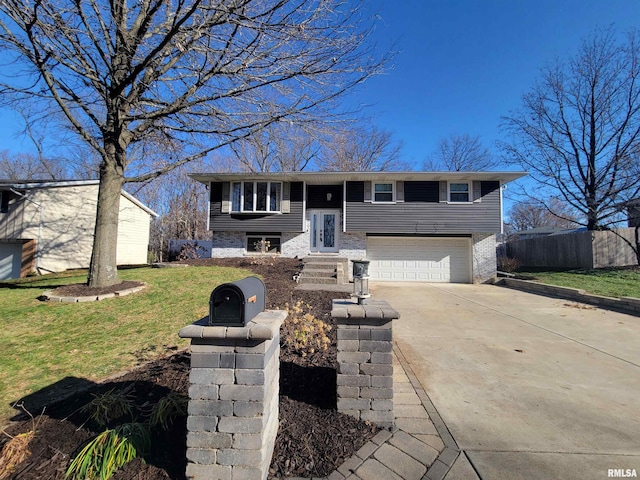 bi-level home featuring a garage and a front lawn