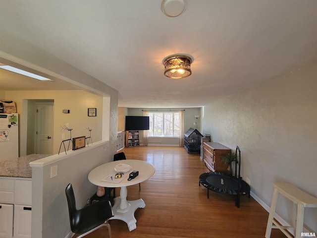 living room featuring light hardwood / wood-style floors and a skylight