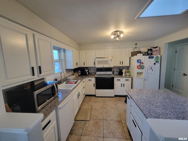 kitchen with white cabinetry, sink, light tile patterned flooring, and white appliances