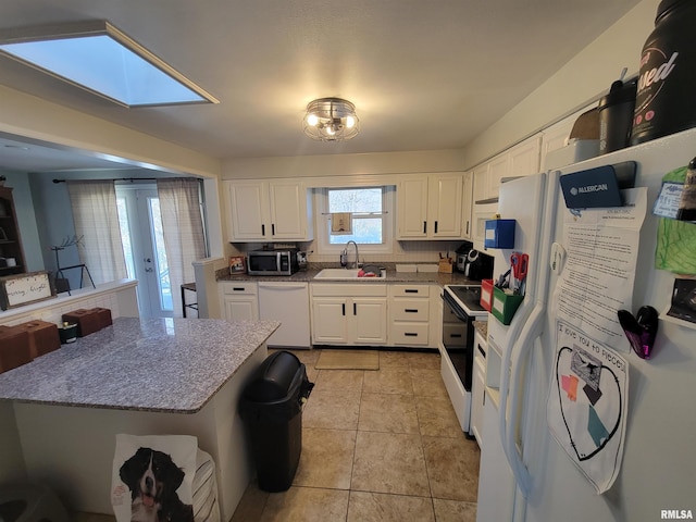 kitchen with sink, white appliances, white cabinetry, and backsplash