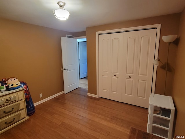 bedroom with light hardwood / wood-style floors and a closet