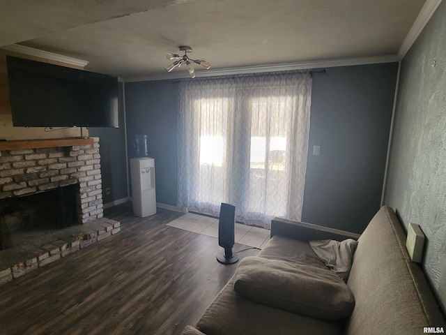 living room featuring hardwood / wood-style flooring, ornamental molding, and a brick fireplace