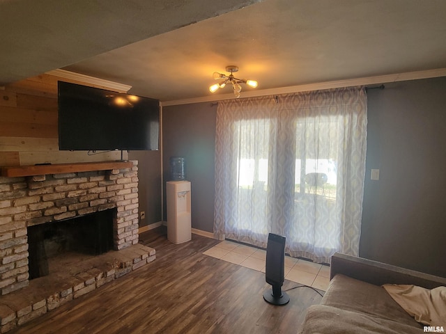 unfurnished living room featuring light wood-type flooring, ornamental molding, wooden walls, and a brick fireplace