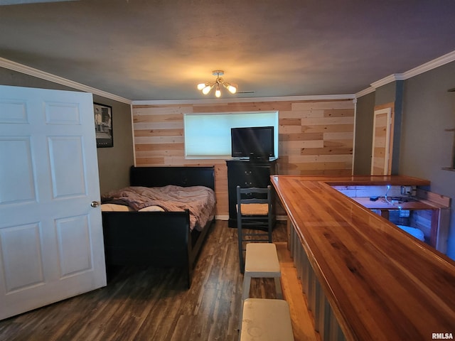 bedroom with crown molding, dark wood-type flooring, wooden walls, and a chandelier