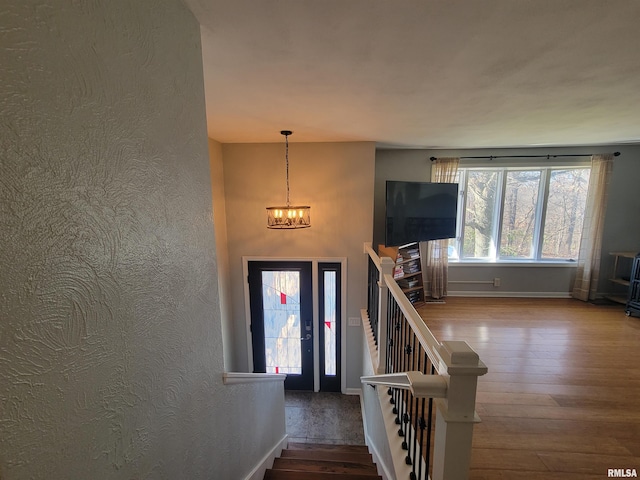 foyer entrance featuring hardwood / wood-style floors and a notable chandelier