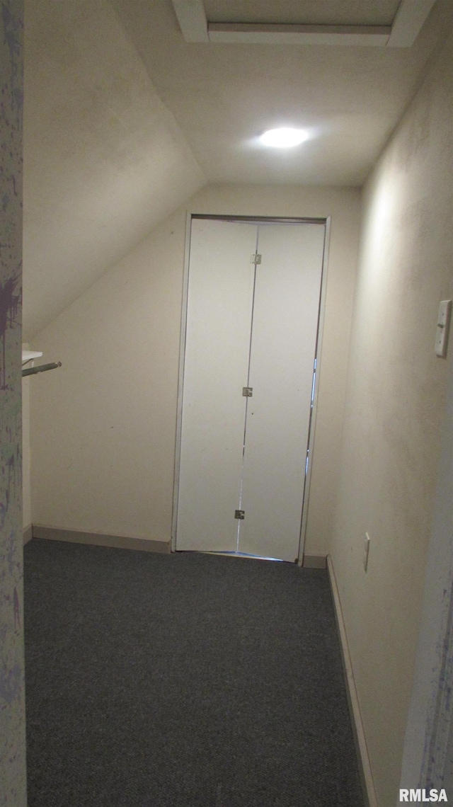 hall with carpet flooring and vaulted ceiling