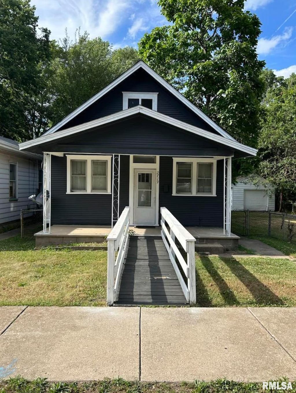 bungalow featuring covered porch and a front yard