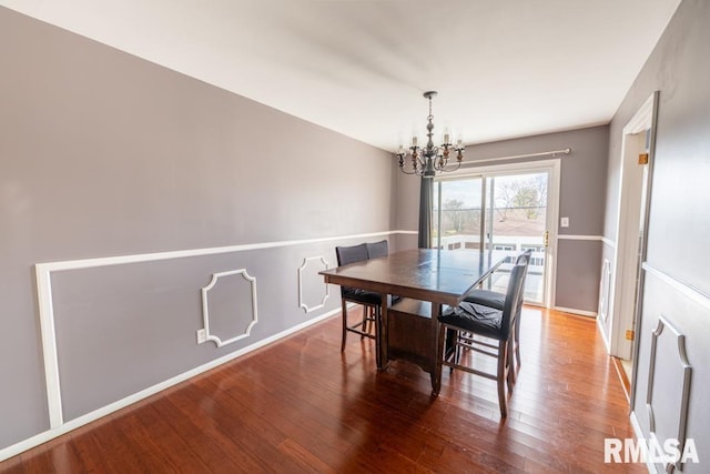 dining room with hardwood / wood-style flooring and a notable chandelier