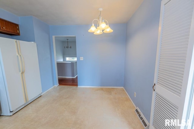 unfurnished dining area featuring a notable chandelier and light tile patterned floors