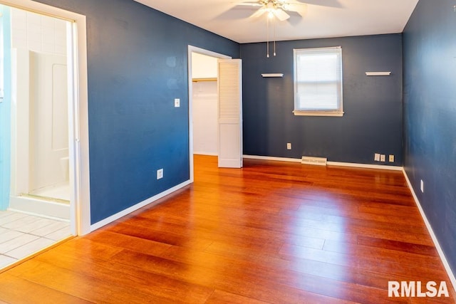 unfurnished bedroom with hardwood / wood-style floors, ceiling fan, and a closet