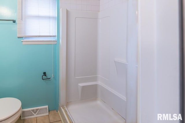 bathroom featuring tile patterned floors, a shower, and toilet