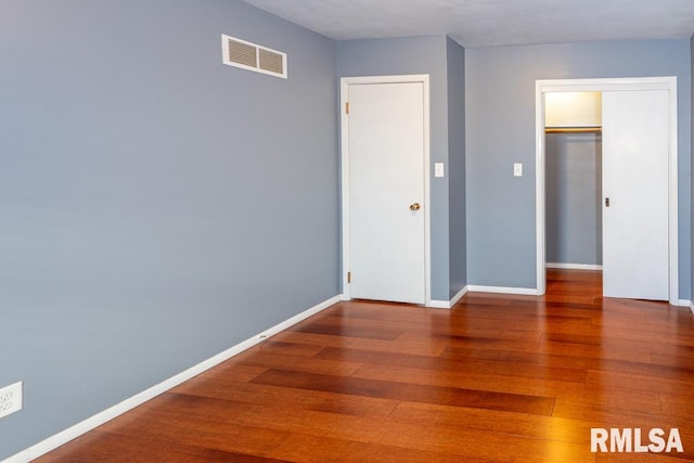 unfurnished bedroom featuring hardwood / wood-style flooring and a closet