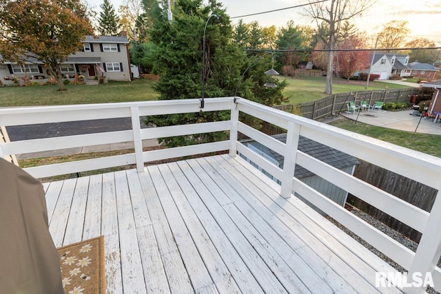 deck at dusk featuring a yard