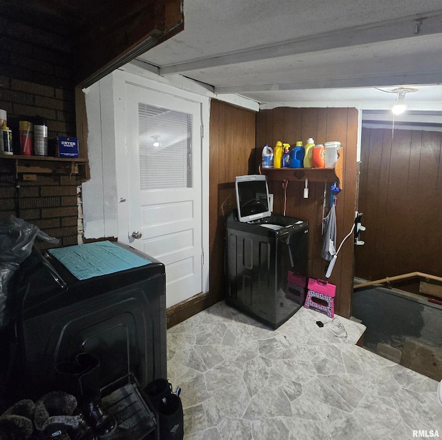 clothes washing area featuring wooden walls