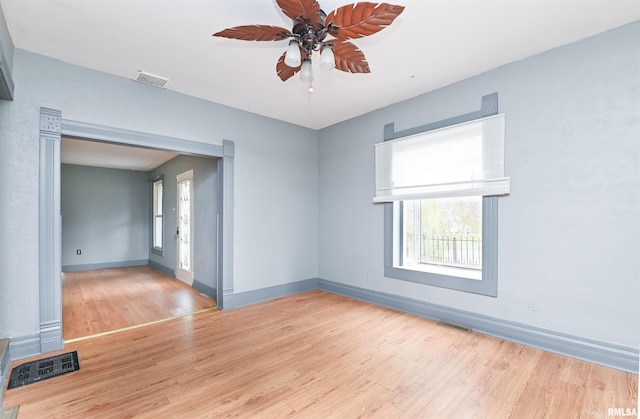 spare room with a ceiling fan, baseboards, visible vents, and wood finished floors