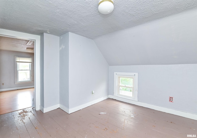 bonus room featuring lofted ceiling, a wealth of natural light, and hardwood / wood-style floors