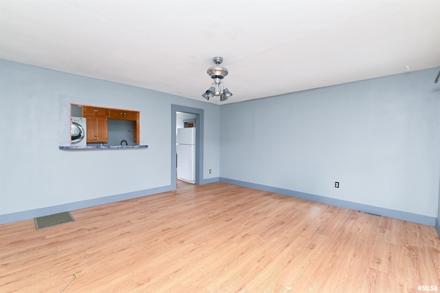 spare room with light wood-style flooring, washer / dryer, visible vents, and baseboards