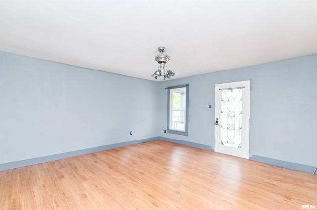 empty room with light wood finished floors and baseboards