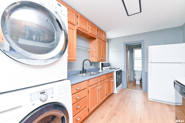 laundry room with laundry area, a sink, light wood finished floors, and stacked washing maching and dryer