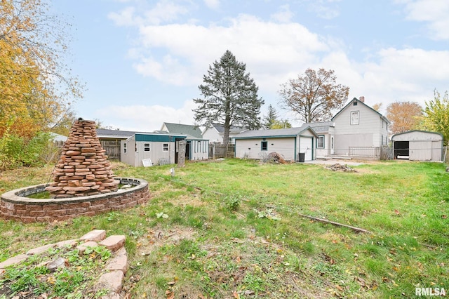 view of yard featuring a shed, an outdoor structure, and fence