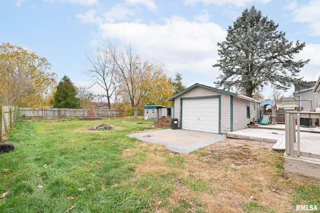 view of yard featuring a garage, an outdoor structure, and fence