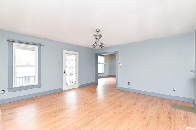 unfurnished room with light wood-style flooring and baseboards