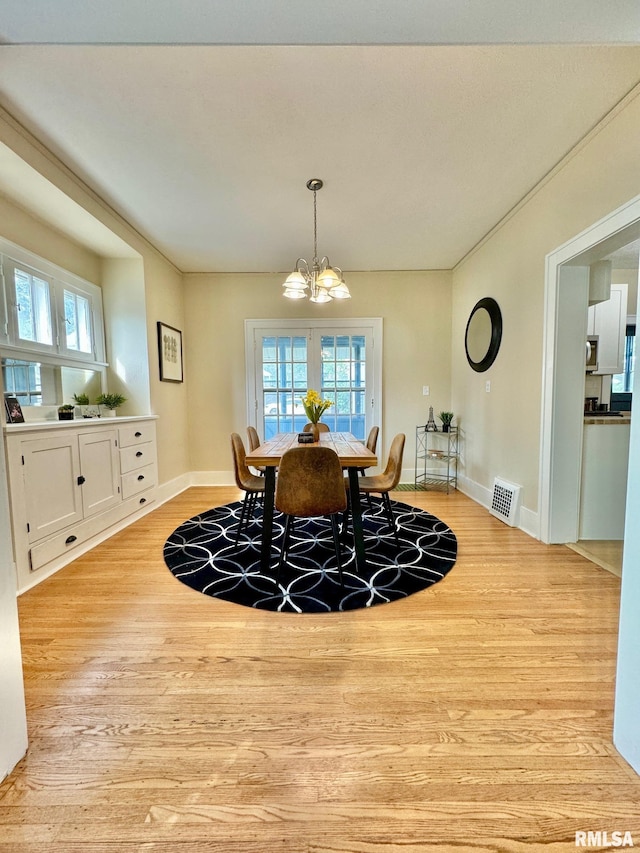 dining area with a notable chandelier and light wood-type flooring