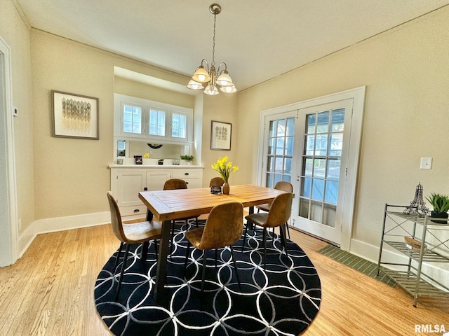 dining area with a notable chandelier and light hardwood / wood-style floors