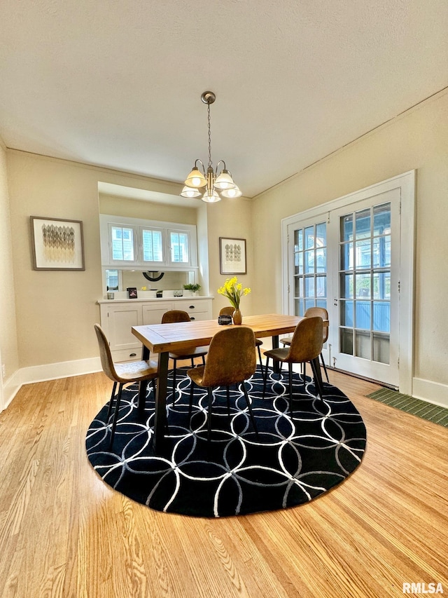 dining space featuring light hardwood / wood-style flooring and an inviting chandelier