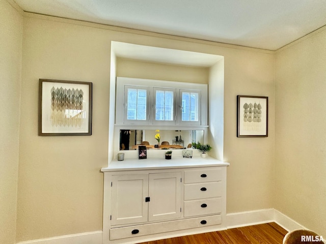 bar with white cabinets and hardwood / wood-style floors