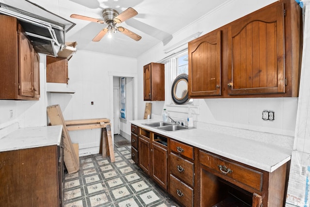 kitchen featuring ceiling fan, ornamental molding, and sink