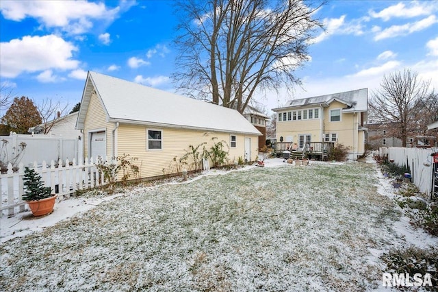 snow covered back of property featuring a yard