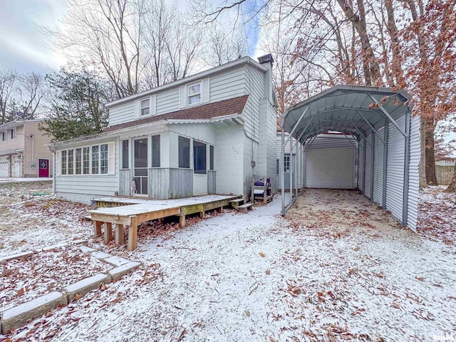 view of front facade featuring a garage, a carport, a deck, and a sunroom